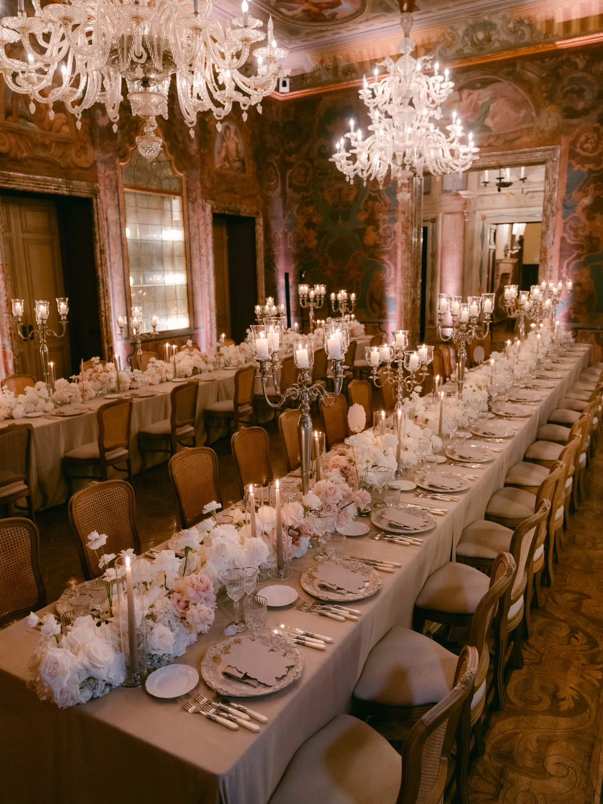 Reception table beneath chandeliers
