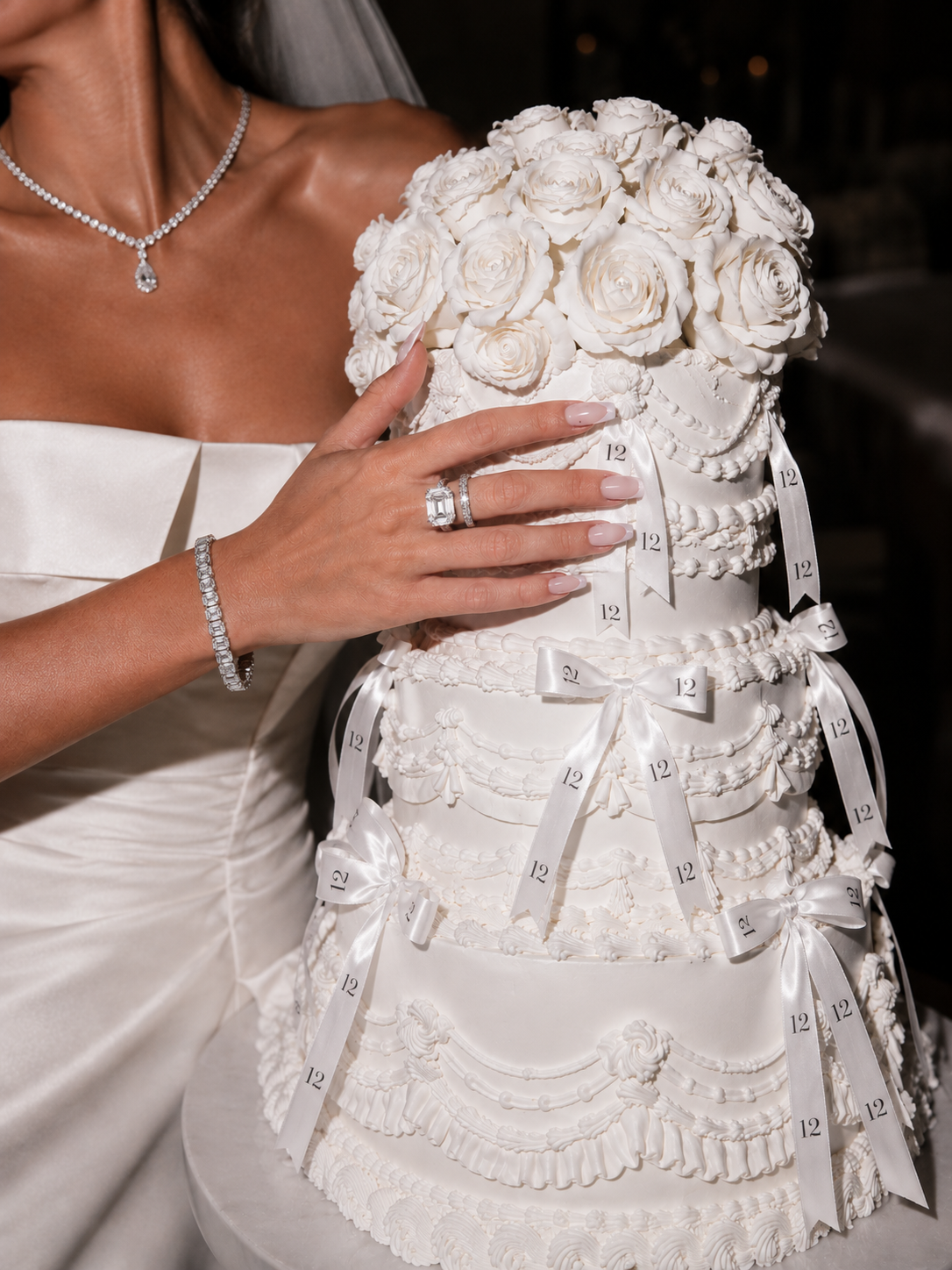 Bride holding a white wedding cake decorated with sculpted roses